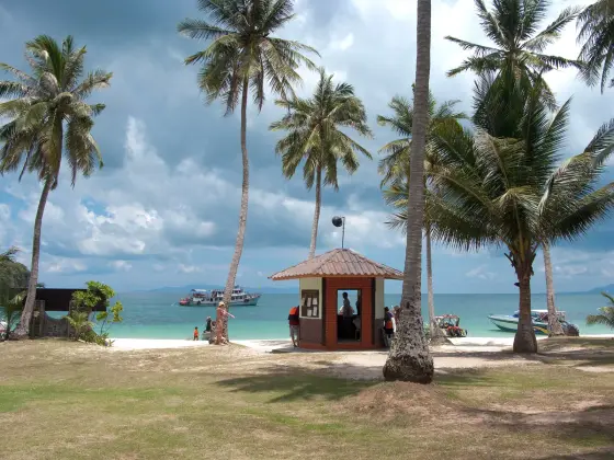 Palm-fringed beach on Ko Wua Talap with tour boats off the shore