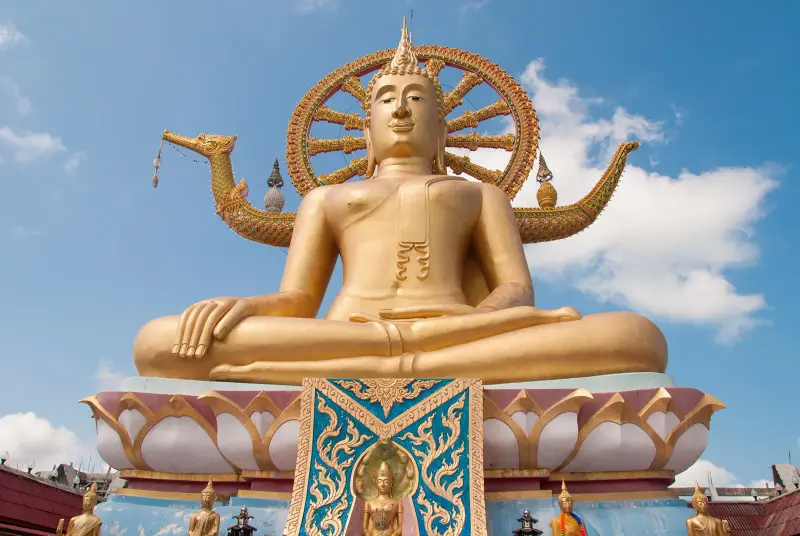The Big Buddha on Samui against the sky, with a lotus base and small Buddha figures below