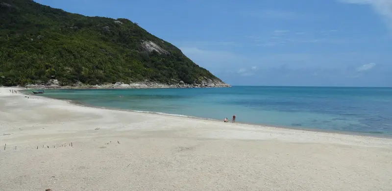 The shore of Bottle Beach along the headland with turquoise water