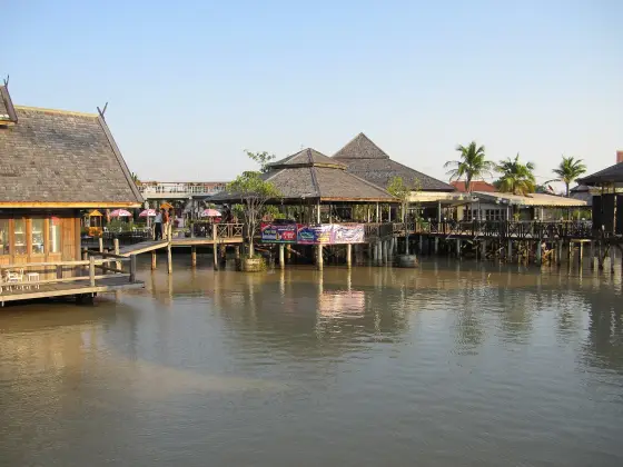 Pavilions on stilts at the water's edge seen from a neighbouring walkway