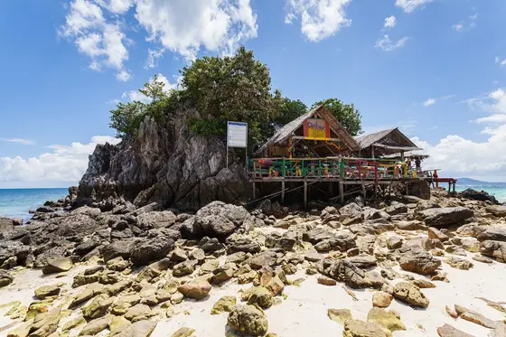 Beach shacks on stilts among the rocks on Khai Nok