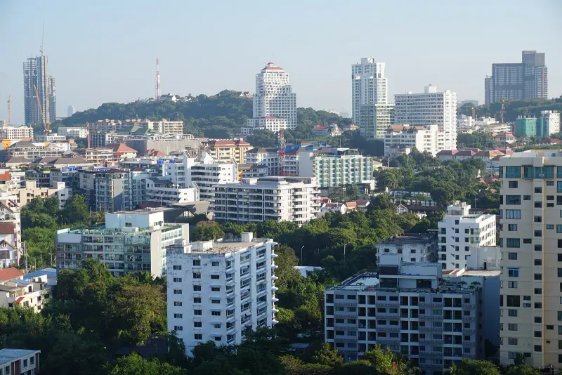 The wooded Khao Phra Tamnak (Pratumnak) hill among apartment blocks, with a radio mast on the summit