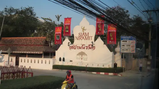 Въездной знак Siam Niramit с красными флагами у дороги, бангкокский театр, 2014 год (тот же проект, что и на Пхукете)