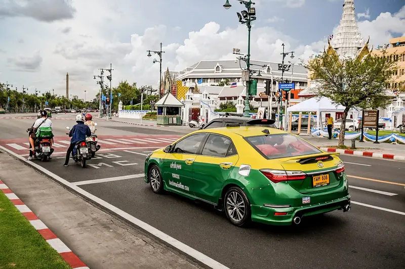 Taxi and motorcycles at a traffic light on Sanam Chai Road in Bangkok